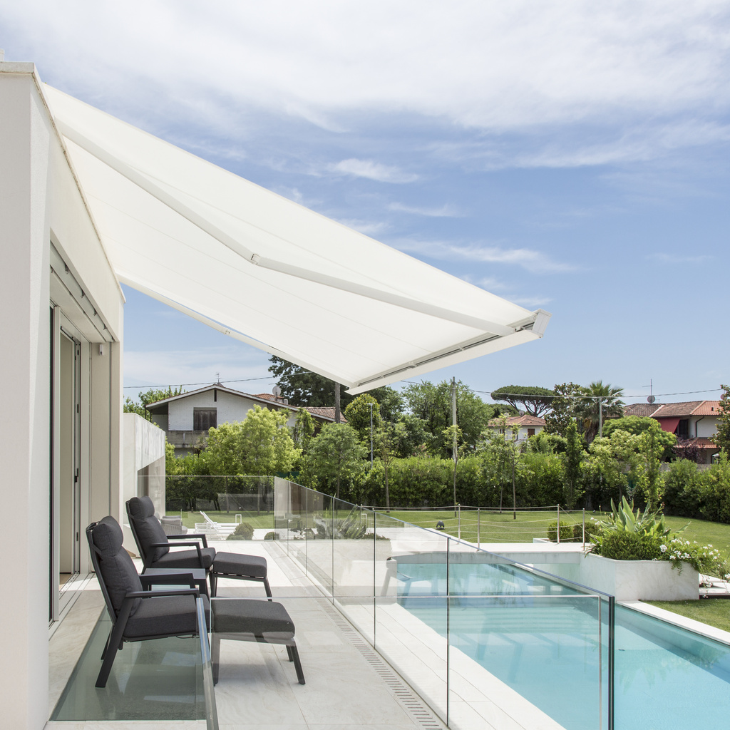 Seitliche Ansicht einer weißen Markise über einer Terrasse mit Liegestühlen am Pool
