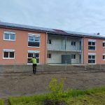 Fassade eines Neubaus in Kapfenberg mit weißen, teils heruntergelassenen Außenrollläden.