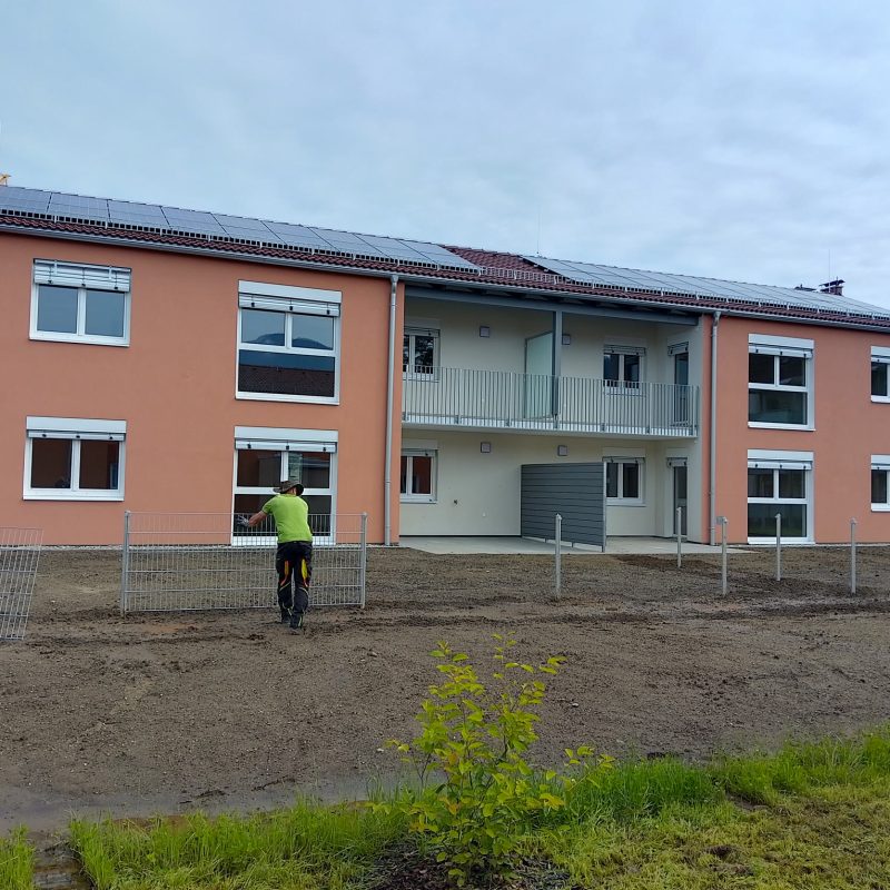 Fassade eines Neubaus in Kapfenberg mit weißen, teils heruntergelassenen Außenrollläden.