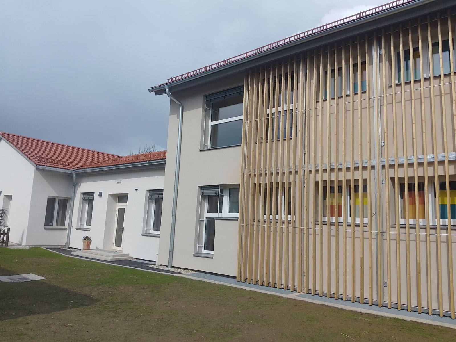 Schul- und Kindergartengebäude in Kitzeck mit Fenstern und Holzlamellen an der Fassade