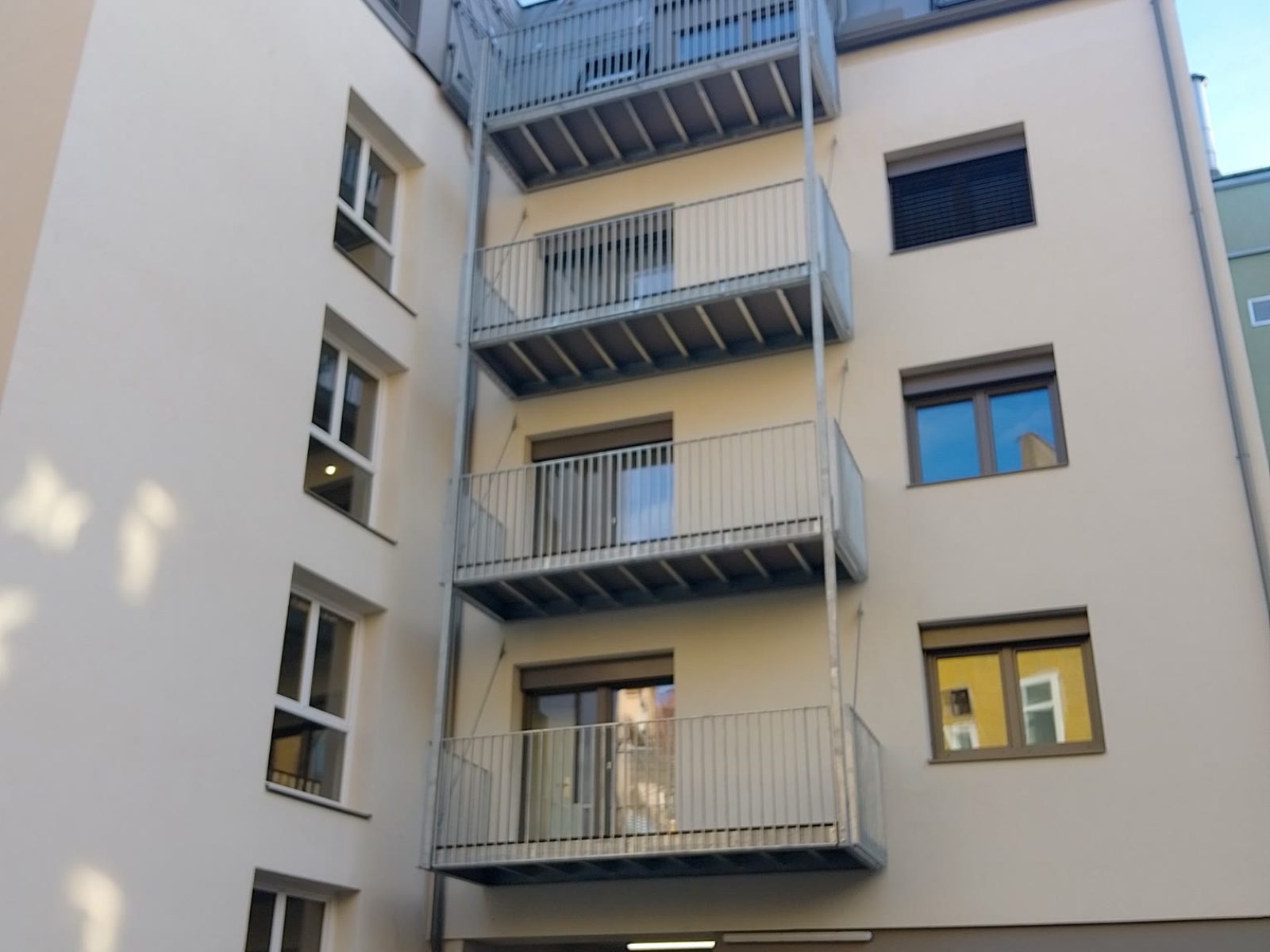 Innenhof-Fassade eines mehrgeschossigen Gebäudes in Graz-Lend mit Fenstern und Balkonen