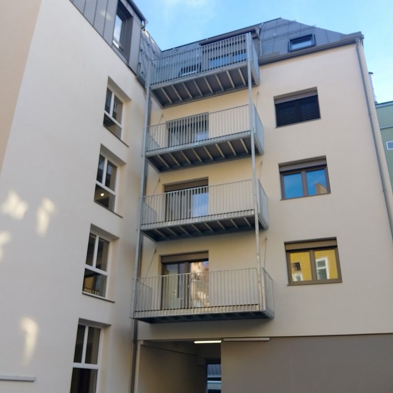Innenhof-Fassade eines mehrgeschossigen Gebäudes in Graz-Lend mit Fenstern und Balkonen