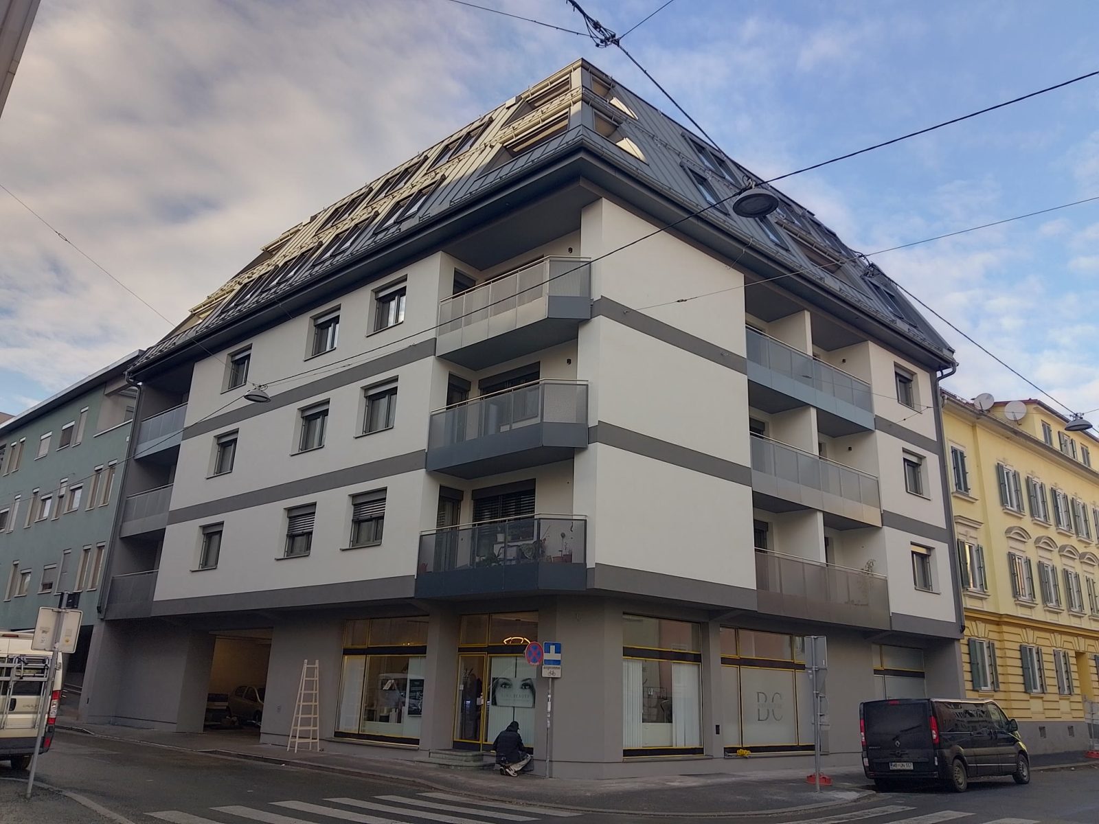 Mehrgeschossiges Eckgebäude in Graz-Lend mit Fenstern, Balkonen und geneigtem Dach