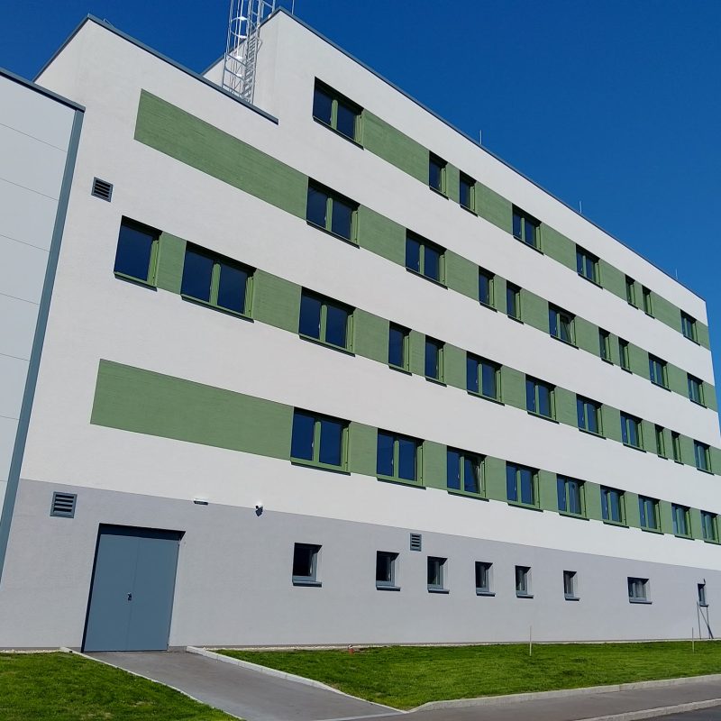 Gebäudefassade mit grünen Fensterrahmen und hellen Wandflächen in Klosterneuburg