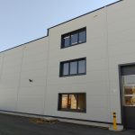Hallenfassade in Klosterneuburg mit übereinanderliegenden Fenstergruppen und sichtbaren Lamellen